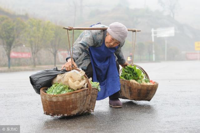 80岁老人挑担子雨中卖菜,留守老人一人撑起生活,不服输不服老