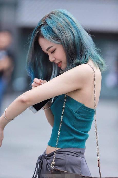 街拍:美女染着蓝绿色的头发,穿着件蓝绿色小背心,侧颜