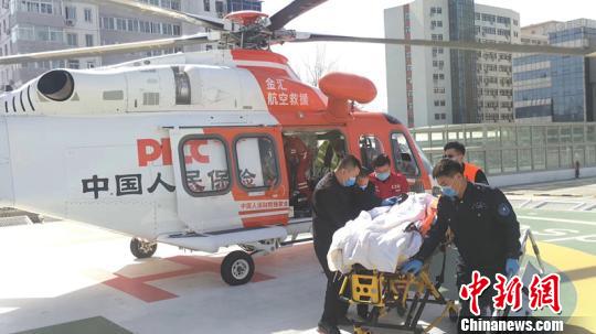  图为伤员被顺利接下直升机。　史亮 摄