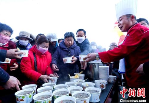 资料图:甘肃张掖厨师在给市民盛免费腊八粥。王将 摄 资料图:甘肃张掖厨师在给市民盛免费腊八粥。王将
