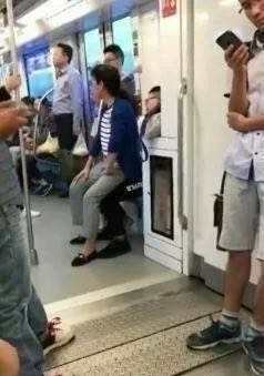 上海地铁一女子抢不到座 竟脱鞋踩在别人座位上