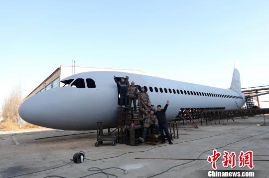 辽宁铁岭6位农民历时一年制成“空客A320”,完工前夕在飞机前合影。