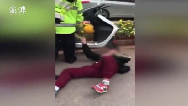 摩托男碰瓷交警演技开挂：抱腿躺地撒泼