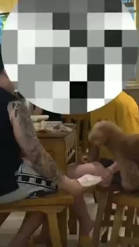 男子饭店用餐盘喂宠物狗