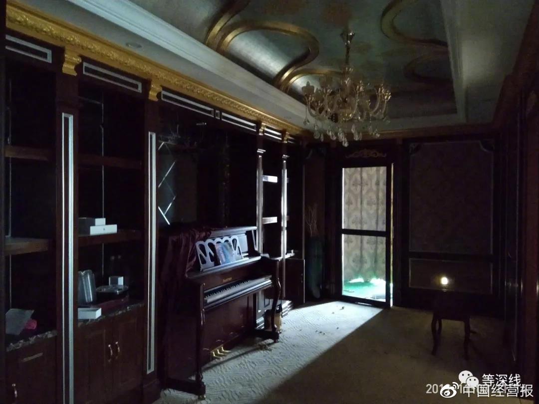 “1号套房”的起居室。出于私密性考虑,阳台上的落地窗帘常年处于关闭状态,该阳台未遮严实的缝隙透进的光线经过灰色纱窗门射进黑暗的起居室中,明亮与黑暗之处形成强烈反差,物件上反射出冷冷的光,透出一丝恐怖气氛。图中铺有绿色塑料假草坪的阳台,是敲空墙壁后,用钢架在外硬生生搭建出的一个阳台。《等深线》记者程维摄