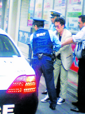 这张由行人在6月8日拍摄的照片显示犯罪嫌疑人加藤智大（中）被警察逮捕。新华/法新