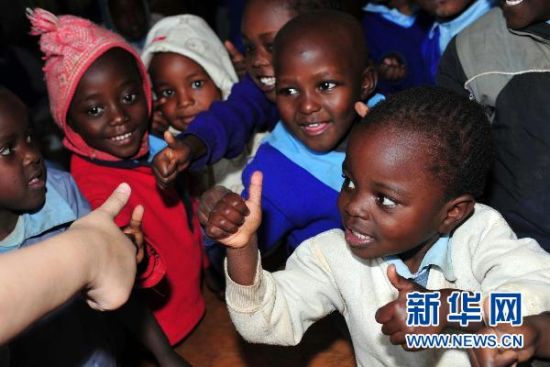 6月21日，在肯尼亚首都内罗毕，参加“明月行动·关爱非洲”大型环保公益活动的一位嘉宾在马萨雷贫民窟的姆赛多北京小学与学生做游戏。