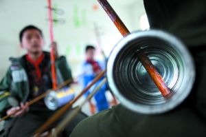 广西天等县民族小学，几位留守学生在上二胡课。学生多，二胡少，老师用奶粉罐和扫把柄制作了这种“奶粉罐二胡”。