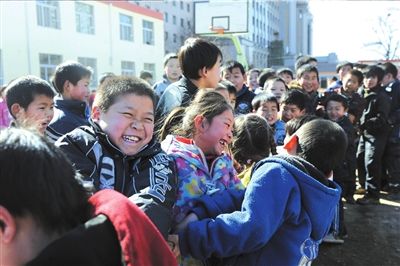 本报与北师大志愿者在石景山黄庄学校与孩子们参加拔河比赛。