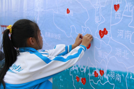 启动仪式上，海南乐东县大安镇木棉小学的孩子在中国地图上一一标记了雪佛兰红粉笔走过的足迹