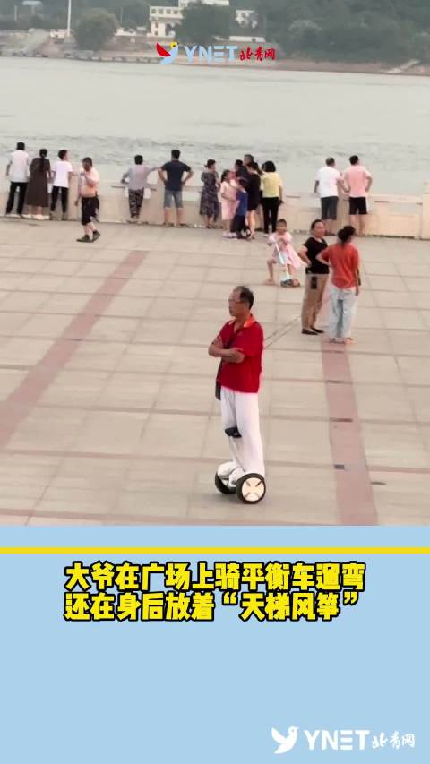 会玩！大爷在广场上骑平衡车遛弯，还在身后放着“天梯风筝”