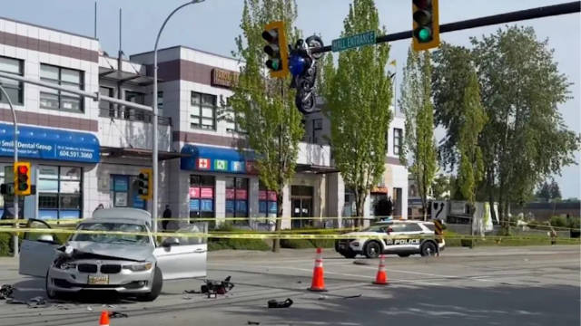 离奇一幕：加拿大一摩托车撞上车辆后 悬挂在红绿灯杆上
