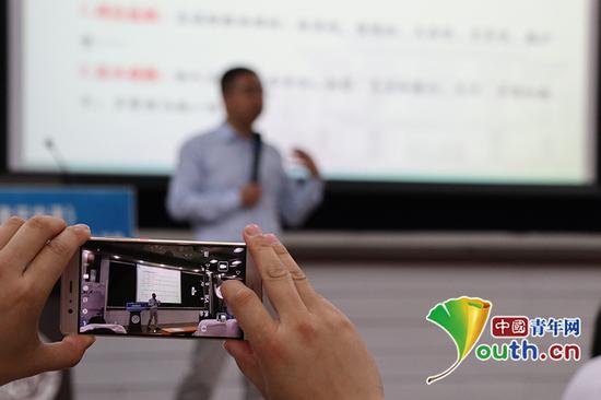 活动现场,南开大学学生用手机拍摄记录讲义。中国青年网通讯员杨至摄