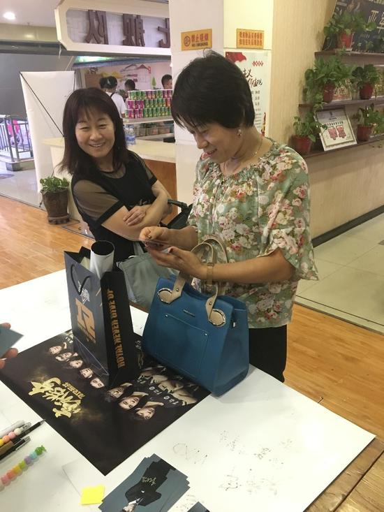 阿姨认真地看着手中的照片