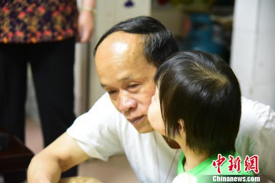 祝春亲吻何长旺的脸颊。 王以照 摄
