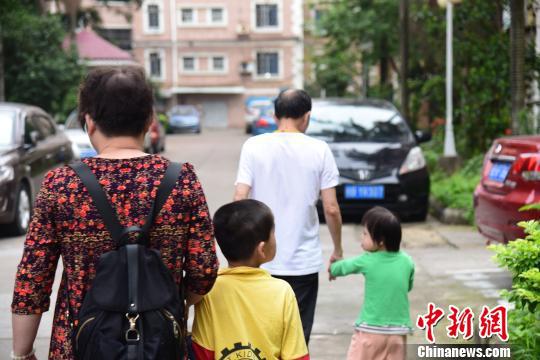 韦福琼夫妇带着两个小孩前往福利院。 王以照 摄