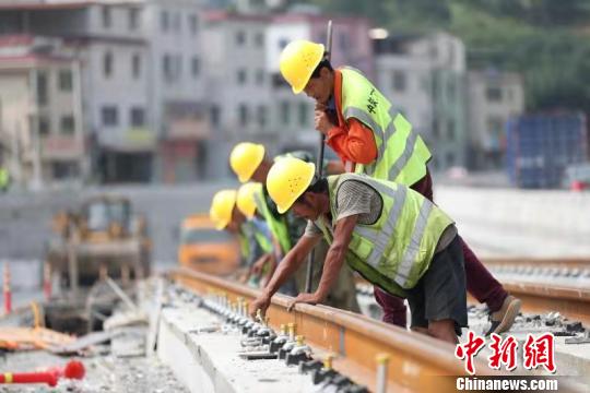 10月14日拍摄的中铁二十二局集团工人正在紧固广州黄埔区有轨电车1号线钢轨。到当日，该线路试验段空载试跑已半个月，取得了成功。　孔祥文　摄