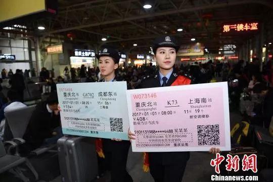 图为两名铁警举着火车票样板为旅客宣传。陈超摄