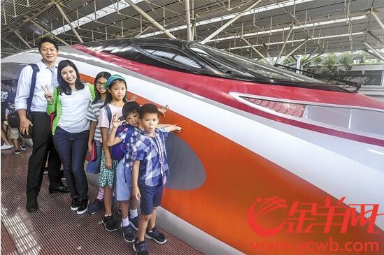 G5736次列车抵达深圳北站，旅客下车后和“动感号”列车合影留念 记者宋金峪摄