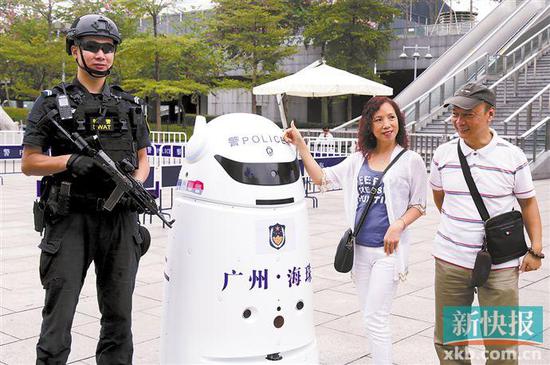 ■在广州塔景区，游客和警用机器人合影。