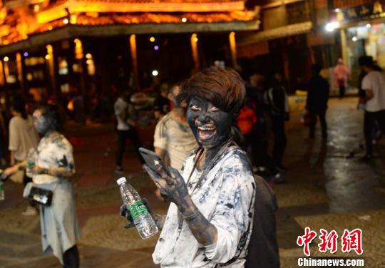 图为游客参与活动现场，被抹得满脸黑。 武敏 摄