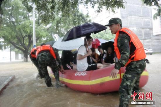 6月8日，广东肇庆市高要二中校门积水最深处达1.5米，300余名考生无法进入高考考场，武警广东省总队肇庆支队派出水上救援突击队，携带2艘冲锋舟紧急驰援，将考生全部安全送至考场。 中新社发 杨璐 摄