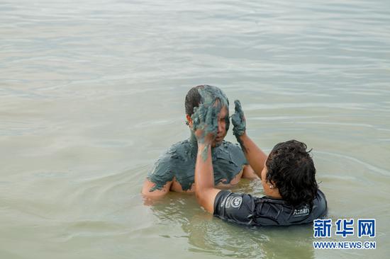 游客在海水中享受泥浆浴