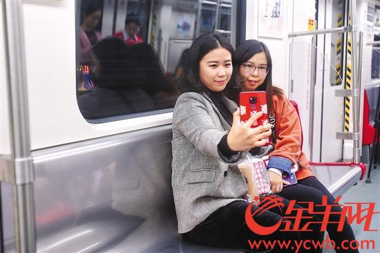 12 月 26 日， 广州地铁举行试乘体验，乘客在即将开通的 14 号线上自拍留念