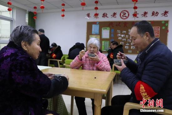 资料图：志愿者陪老师喝粥。(图文无关)中新社发 余秀娟 摄