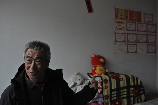 2月3日,农历腊月二十九。李玉宝特意把记者拉到儿子的房间,墙上贴满孙女的奖状,这是他的骄傲。 新京报记者 吴江 摄