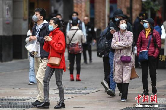 1月26日，广州市民众佩戴口罩走过北京路步行街。中新社记者 陈骥旻 摄