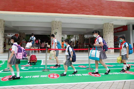 广州市天河区华康小学学生排队测量体温。