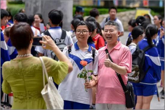 2018年6月17日，中考第三天。广州市第四中学考场，考试结束了，一家人在校门口拍照留念。 信息时报记者 陈文杰 摄影