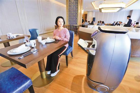 智能送餐机器人在为顾客送餐。