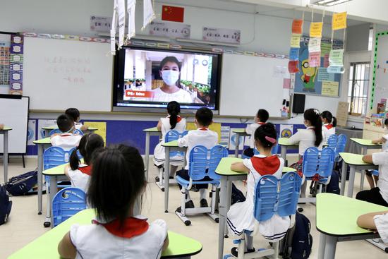 白云区中大附属外国语小学高年级学生给低年级学生加油打气。