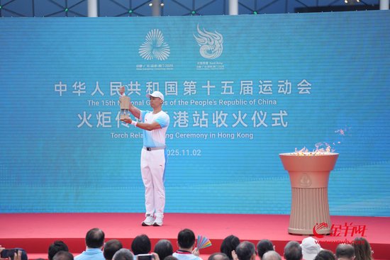 工作人员在收火仪式上点燃火种灯并向观众展示