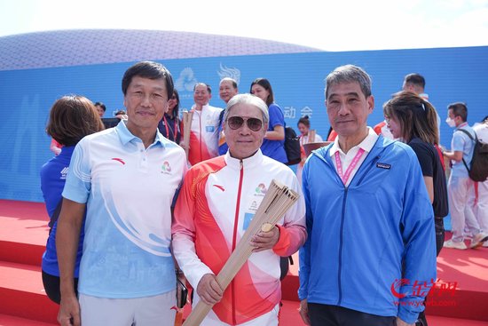 收火仪式结束后，霍震霆（中）接受羊城晚报记者采访