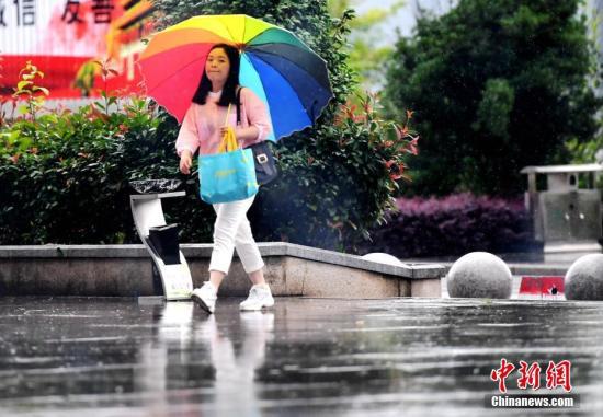 5月7日,福建省三明市将乐县一位市民在雨中出行。 中新社记者 张斌 摄