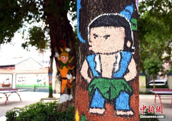 资料图:树木被画上了葫芦娃中的水娃图案。 邓璐 摄