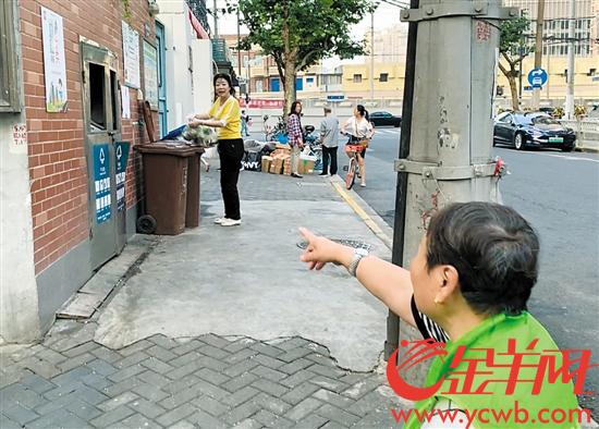 上海街头，志愿者提醒居民正确投放垃圾 记者 梁怿韬 摄