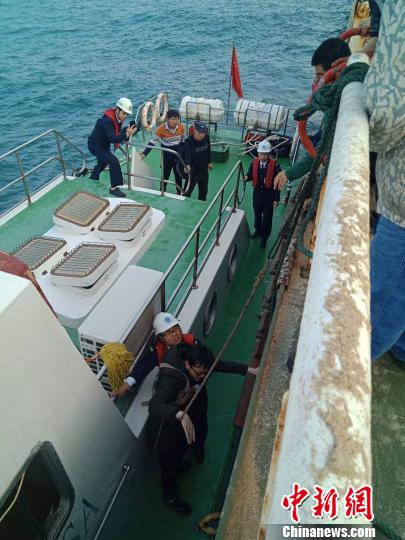 图为正在将突发疾病船员转移到海巡执法船上 惠州海事局提供 摄