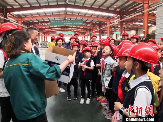 图为在包装纸板纸箱加工车间，工作人员讲解纸箱的制作过程，并结合日常生活普及垃圾分类的知识。　杜萍 摄
