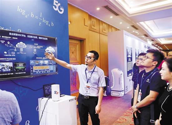 近日，中国电信5G创新合作大会上，工作人员向嘉宾介绍5G的相关产业。