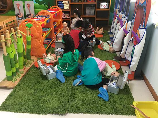 小班孩子们在为洋娃娃包扎伤口游戏中学习对自己的生命保护。