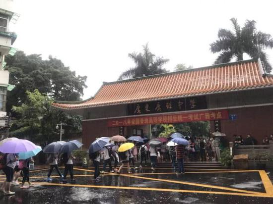 今年高考期间正值暴雨,考生冒雨进入广雅考点参加高考。