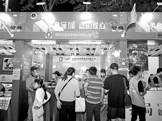 在饭饭得展位前,市民现场品尝特色美食。