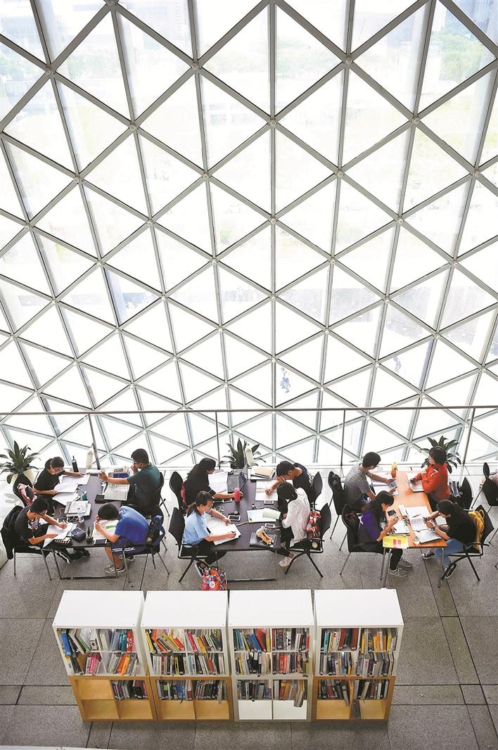 ▲中午时分,深圳图书馆通透宽敞的阅读大厅内座无虚席。 深圳晚报记者 冯明 摄