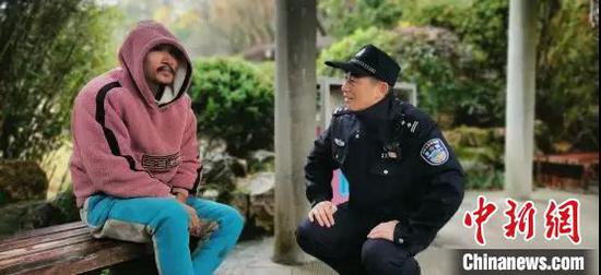 图为:民警试图和流浪男子交流 椒江供图 摄