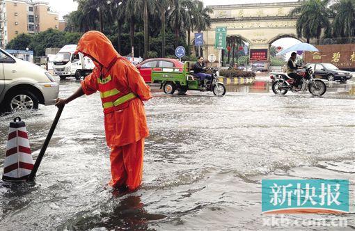 ■大雨之后,广州碧桂园前水浸严重,市政工人在疏通下水道。