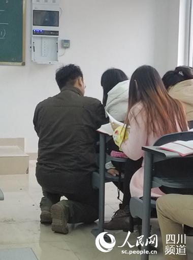 图为唐宇老师正半跪着为学生讲题。（刘金松 摄）